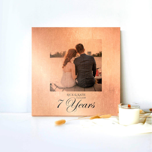 Copper 7 year anniversary photo plaque leaning against a white backdrop with a candle and silk cloth, 7th anniversary copper