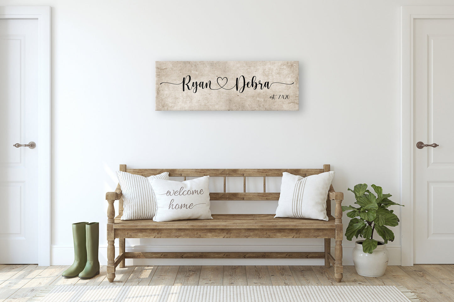 rustic cotton canvas name sign, with 2 first names connected by a heart in a whimsical and playful typeface. A personalized name sign on vintage cotton hangs on wall above bench in entry of home.