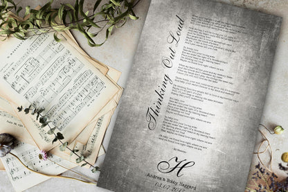 Vintage-style tin wedding song plaque on a tabletop beside aged sheet music and greenery, a 10th anniversary tin gift