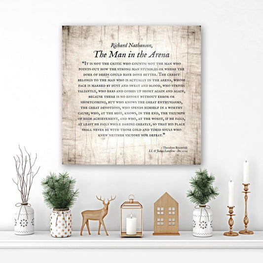 wooden plaque featuring the iconic man in the arena speech, perfect for personalized gifts for him - sign displayed on wall surrounded by holiday themed greenery and decor. Sign includes the recipient's name and a dedication at the bottom. A square or 1;1 aspect ratio in an aged birch finish.