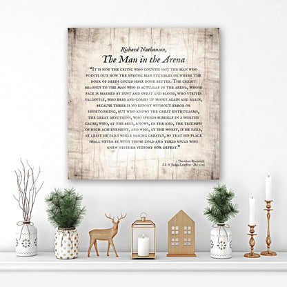 wooden plaque featuring the iconic man in the arena speech, perfect for personalized gifts for him - sign displayed on wall surrounded by holiday themed greenery and decor. Sign includes the recipient's name and a dedication at the bottom. A square or 1;1 aspect ratio in an aged birch finish.