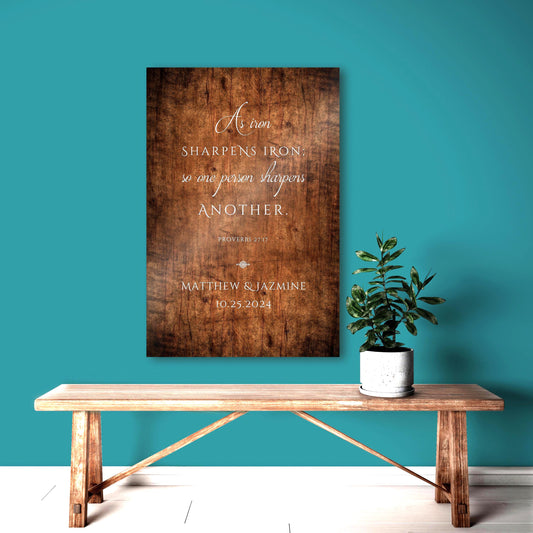 The Christian Iron sharpens iron wooden plaque for couples is stained in a rustic reddish brown with wood grain and wood imperfections making it a showstopper. This one is inscribed with the verse Proverbs 27:17 using elegant script and lettering. A decorative motif sits beneath the bible verse as an anchor to set the verse apart from a dedication or personalization below. This sign was purchased as an anniversary gift and is personalized with the couple's names and union or established date
