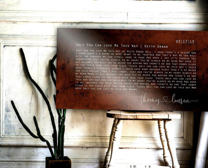 custom song lyric art on metal, large bronze sign with song lyrics, rustic and personalized with his and her names connected by a heart. seated on a wooden chair