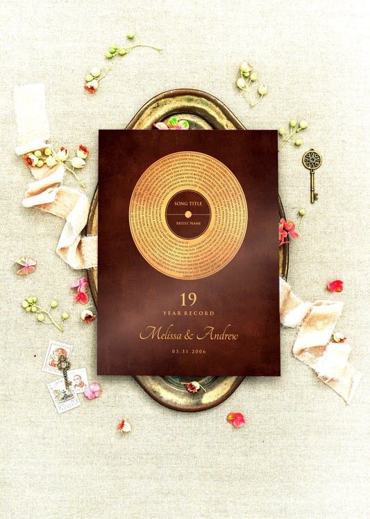 Custom Oil-Rubbed Bronze Anniversary Record Plaque is center frame, viewed from romantic, aerial perspective. It's set on a brass tray and surrounded with sprigs of poppies, and with a couple of antique keys on a linen cloth.

The plaque is set on a burnished bronze finish - record motif occupying an aged bronze finish with an overlay of the song lyrics of choice, with credit on the label. Below is the anniversary year, couple's names and union date. 

Photo courtesy of Honeycomb Proverb
