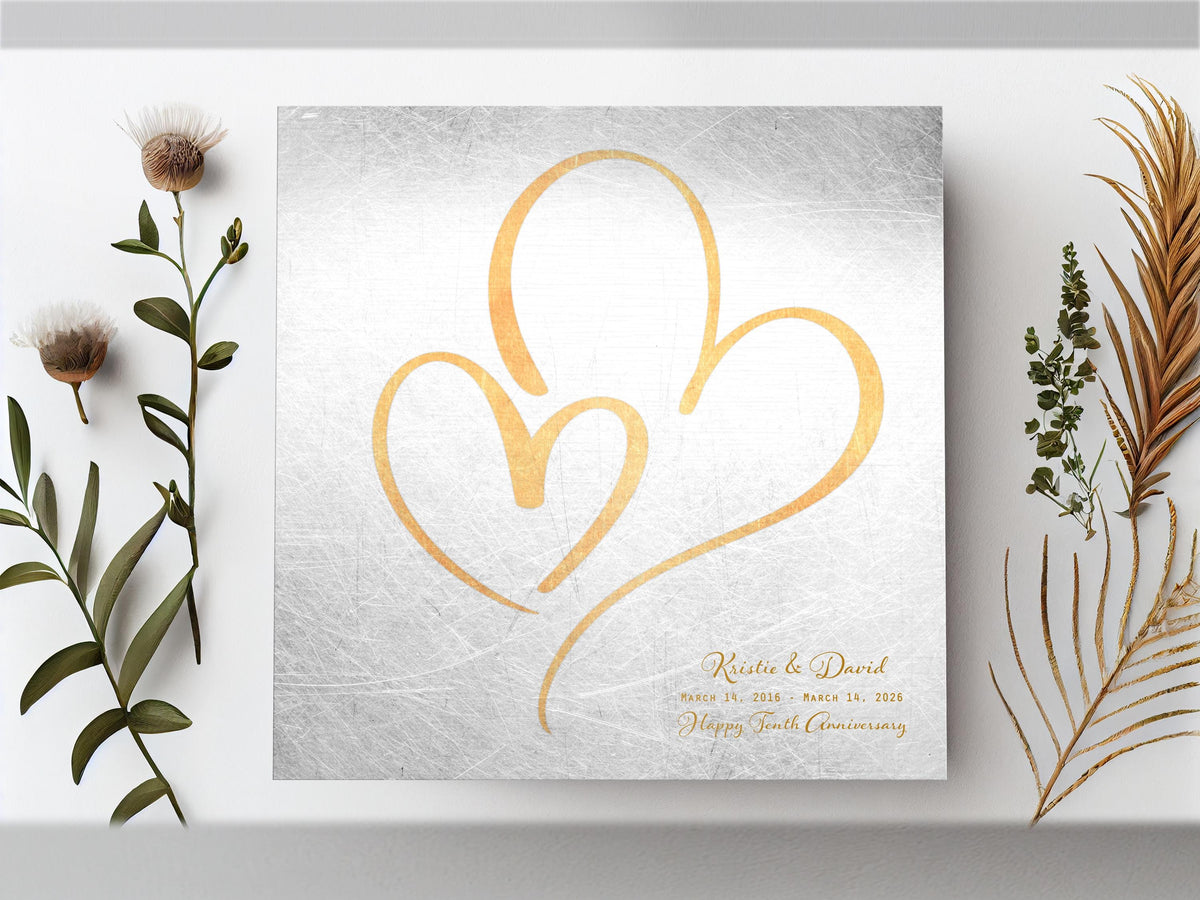 Distressed tin hearts plaque, a large brass-toned heart around a smaller one, names and a tenth anniversary wish
