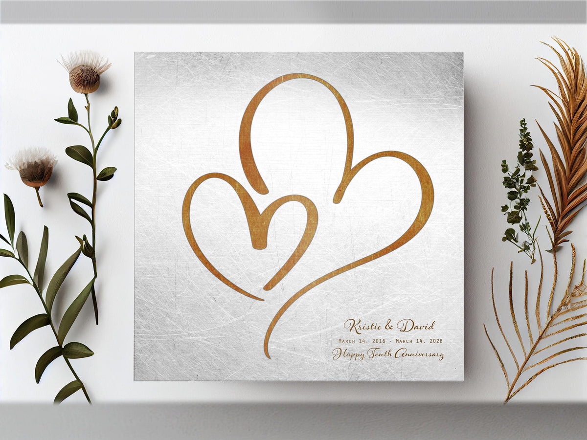 Distressed tin hearts plaque, a large bronze-toned heart around a smaller one, names and a tenth anniversary wish
