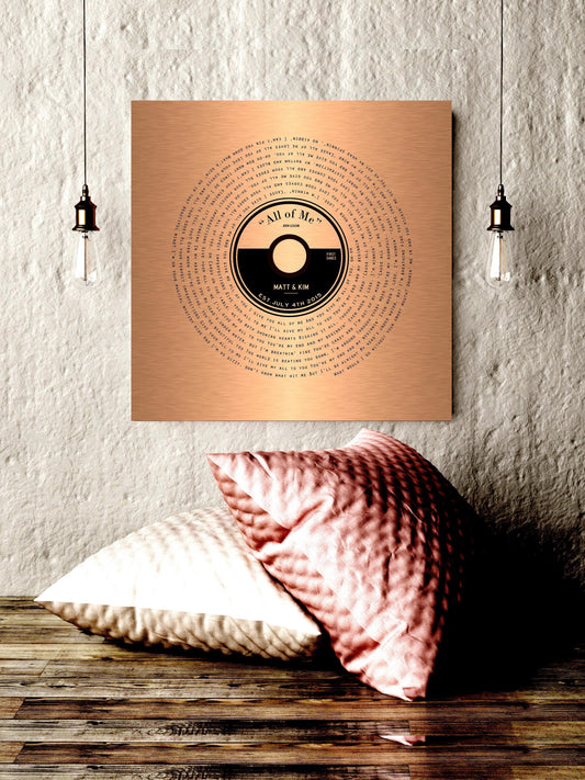 A custom copper song record art with personalized record label and song lyrics that wind around the round record label to crest a vinyl record design.