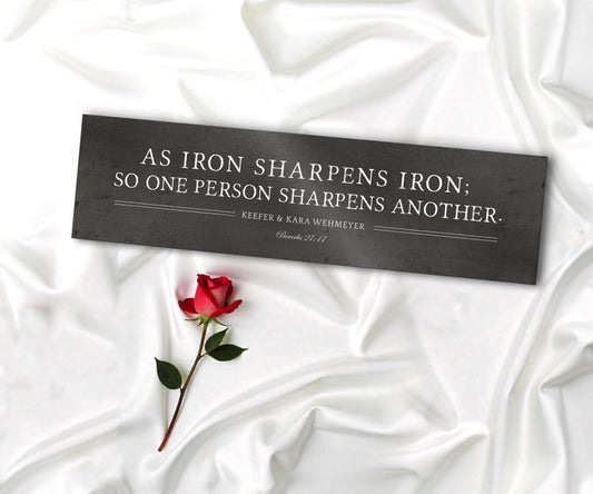 As iron sharpens iron so one person sharpens another is inscribed on a wide format metal plaque and the names Sara and Alex and their union date is under the bible verse.   Photo courtesy of Honeycomb Proverbs