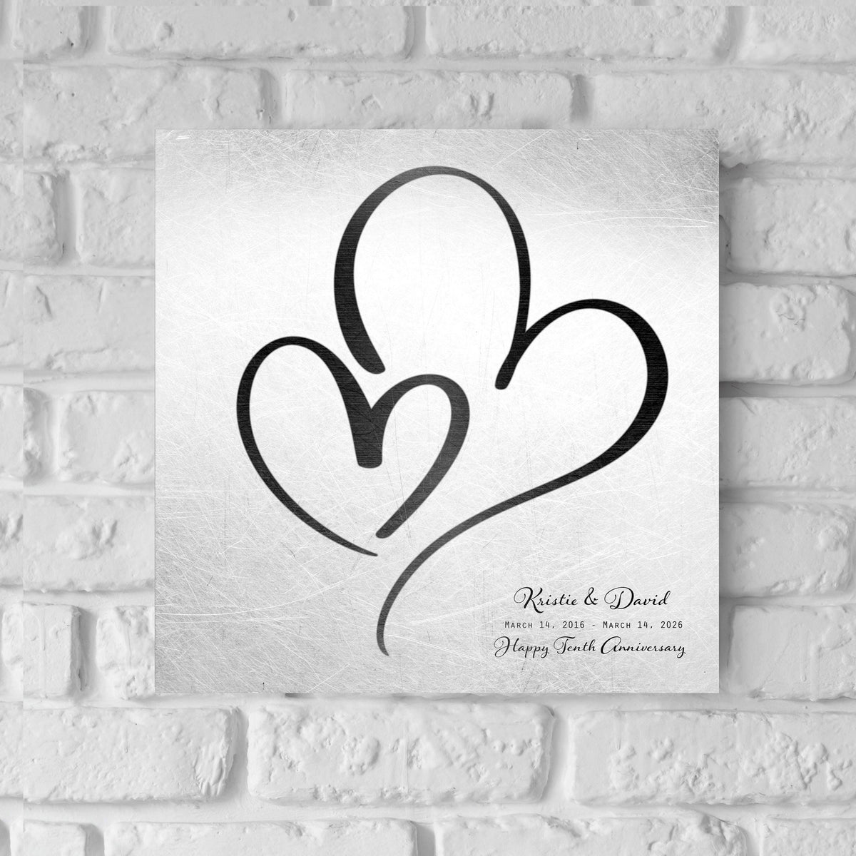 Distressed tin hearts anniversary plaque in black-toned hearts with first names, shown as a 10th anniversary tin gift