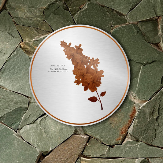 Single Bronze Lilac sprig on round silver metal plaque with the inscription, "I still do" with anniversary date with the phrase "Our Bronze & Lilac Wedding Anniversary" below, in a discreet size using an elegant calligraphy and upper case type-face pairing.
