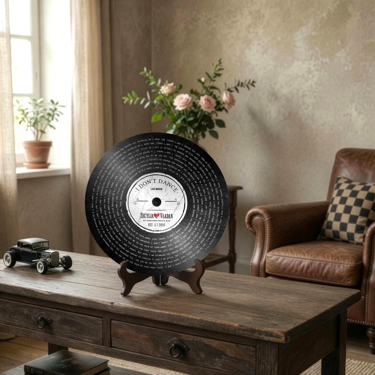 Round Record Plaque with names, song lyrics, and established date sits on easel on wooden desk.