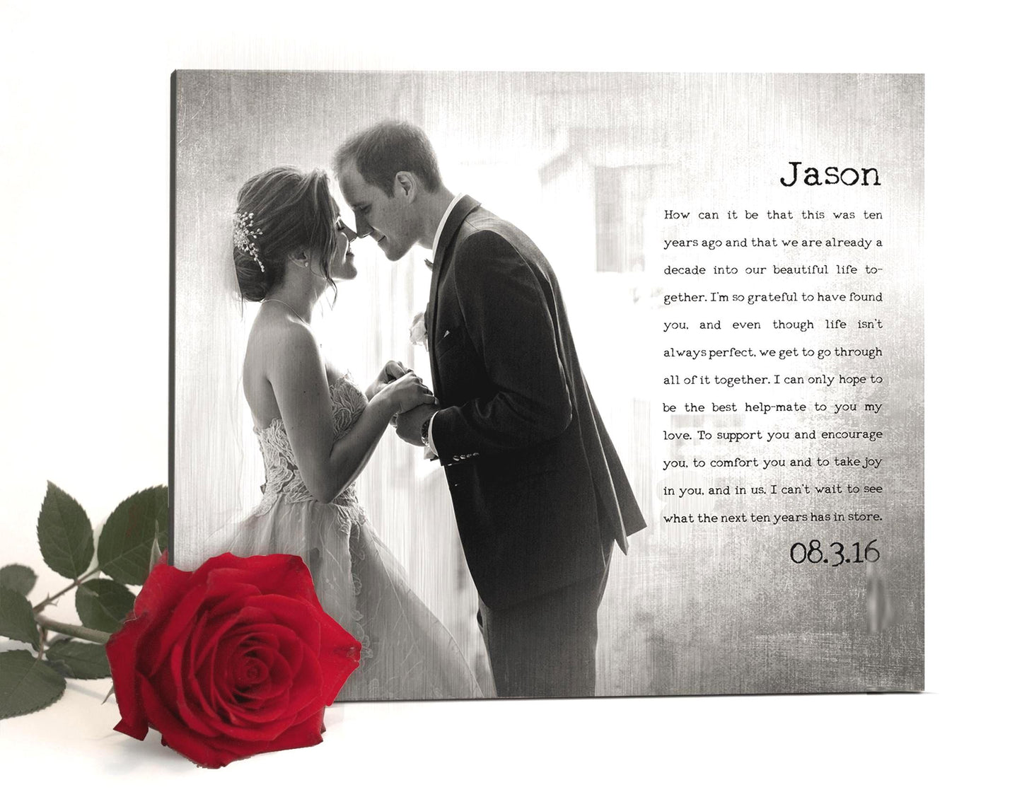 Photo printed on metal as a tin or aluminum anniversary gift for husbands and wifes. This metal photo decor is crafted on tarnished metal and is inscribed with a personal message to Jason from his wife. It features a black and white and tarnished photo of them on their wedding day to mark their 10th wedding anniversary. Their wedding date is also inscribed onto the plaque. The photo art is isolated on a white background with a single scarlet rose on the lower left of the frame.