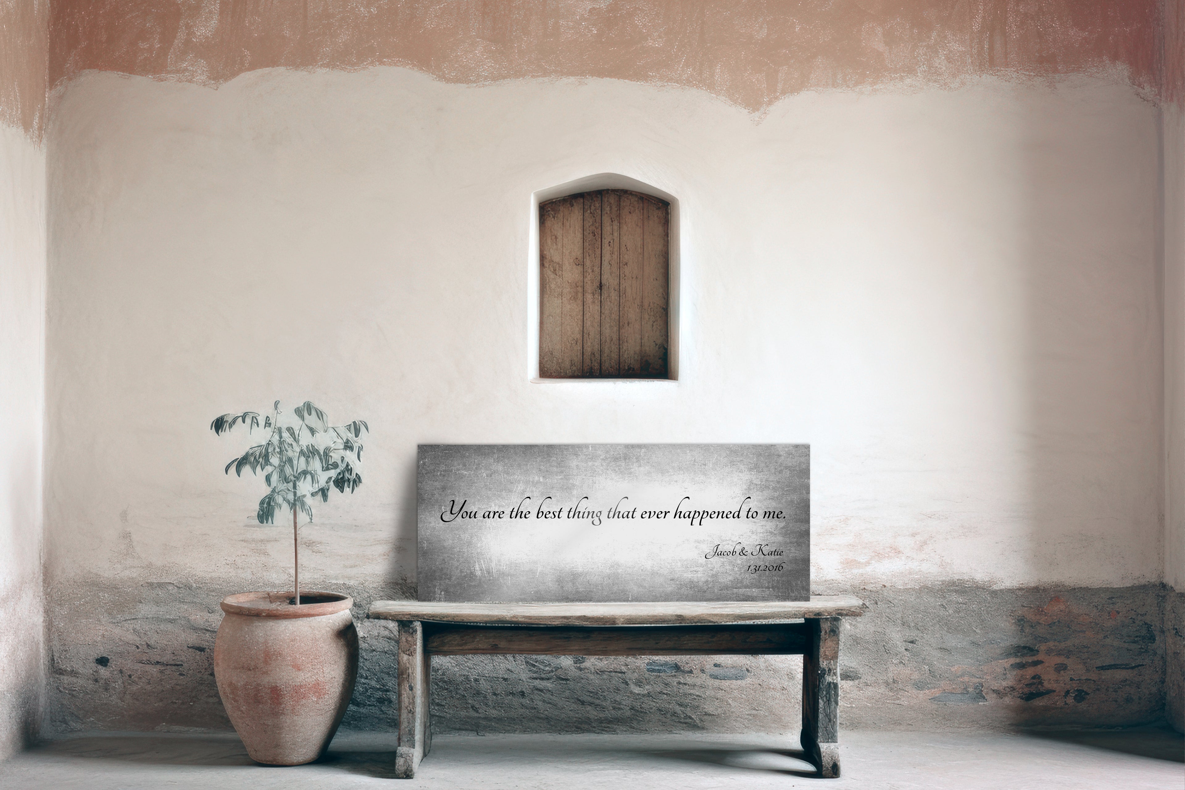 Wooden bench with a tarnished metal quote sign on a textured wall with a plant beside it